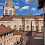 Vista dal balcone di un edificio storico con torre | Casa Vacanza San Salvario